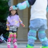 Kids skating – Two children rollerblading outdoors with protective gear